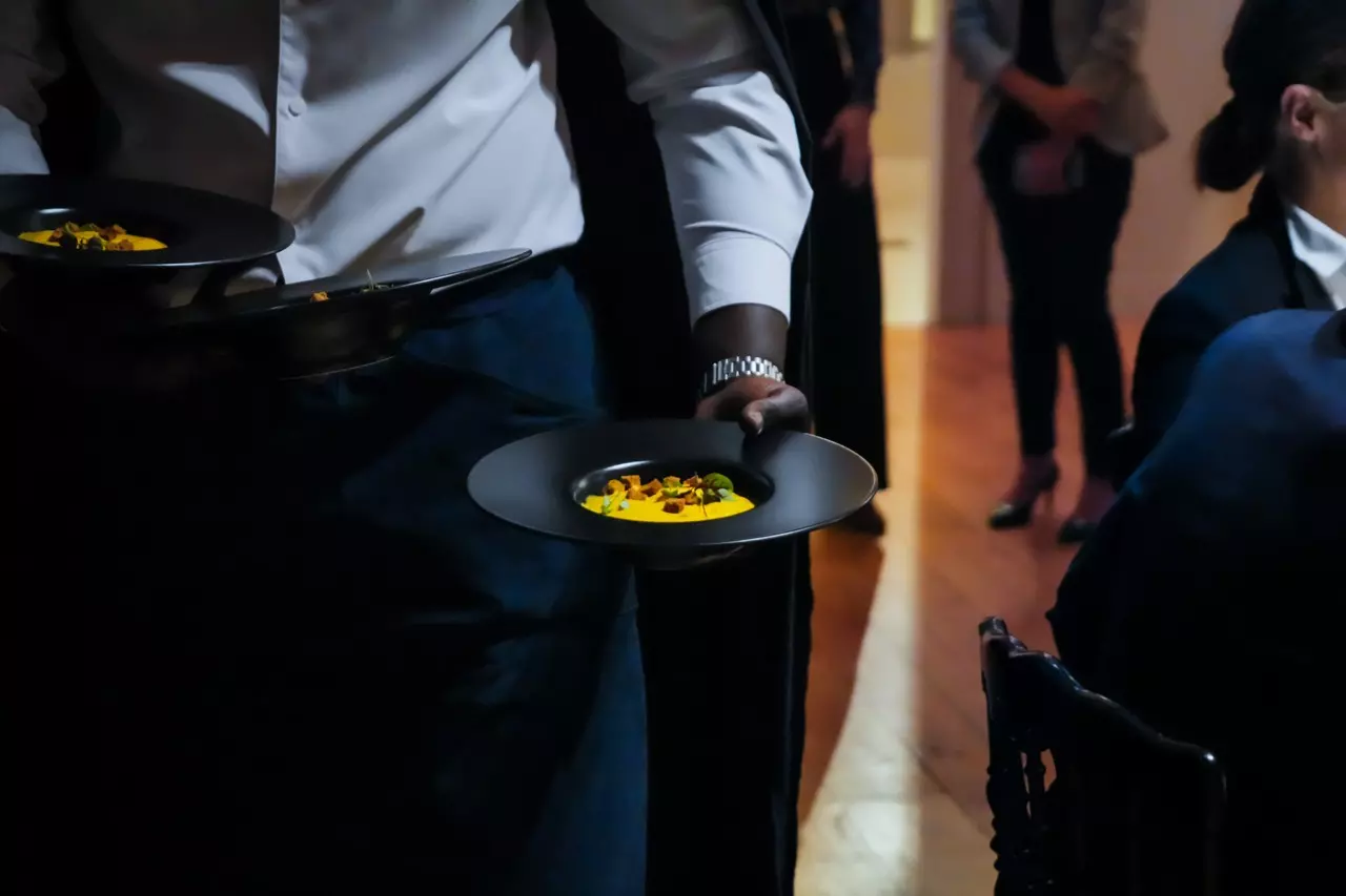 Serveur présentant une assiette lors d'un service en salle