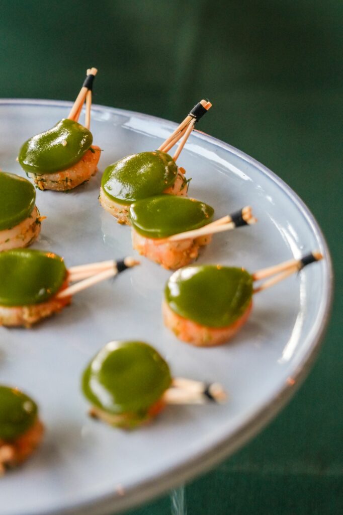 Bouchées nappées de sauce verte sur un plateau