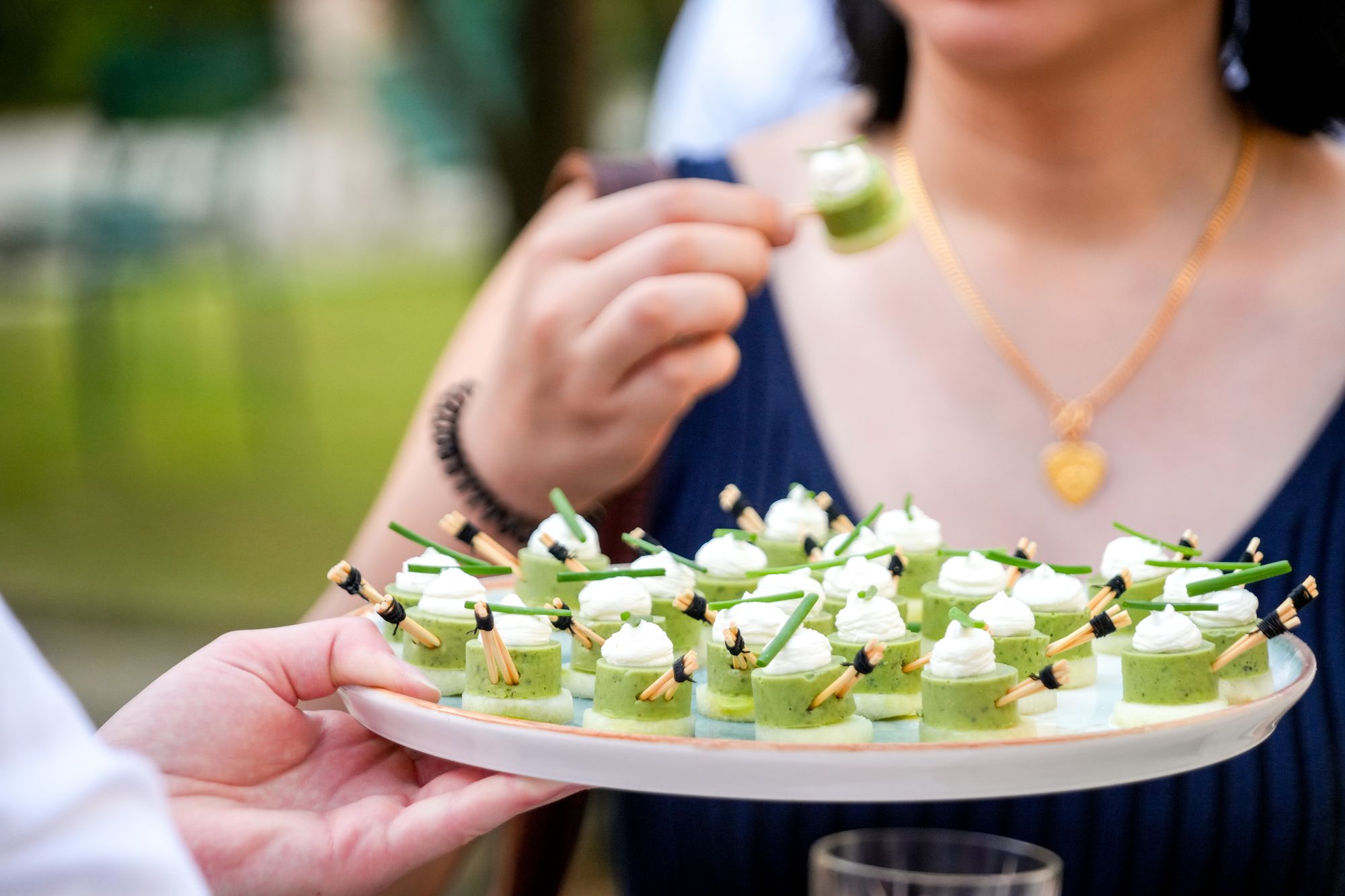 Invitée dégustant une bouchée verte devant un plateau