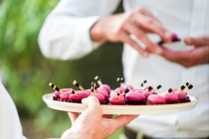 Plateau de bouchées roses présenté par un serveur