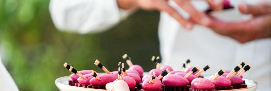 Plateau de bouchées roses présenté par un serveur
