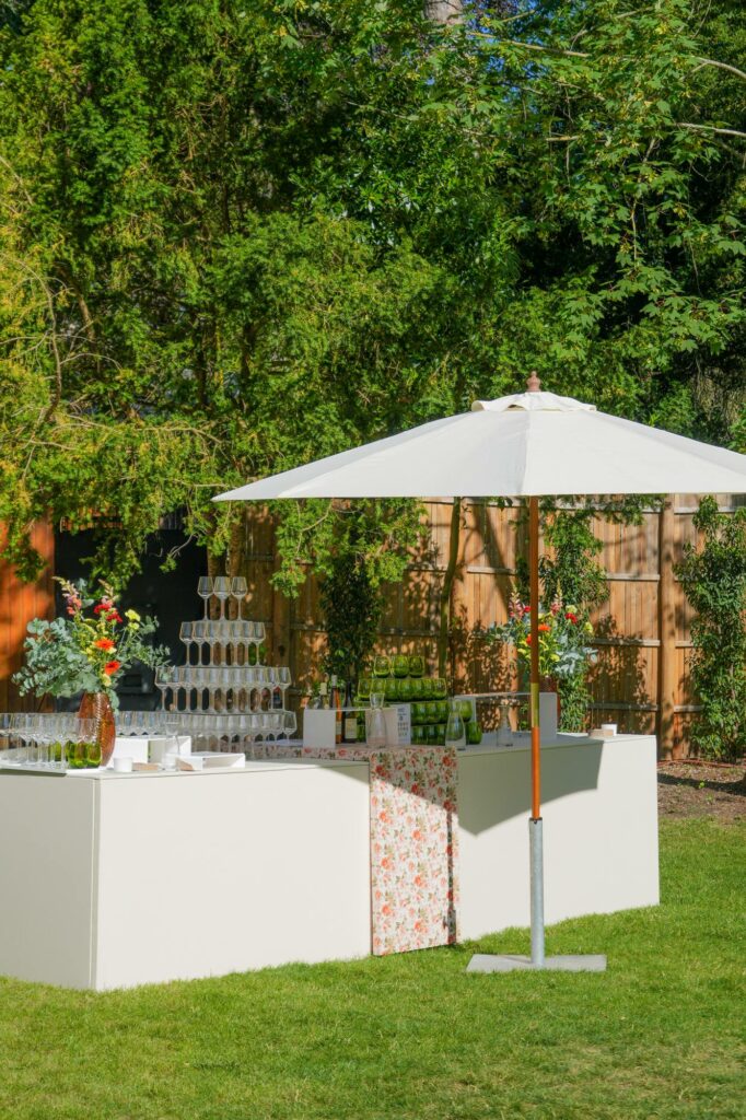 Buffet du cocktail dressé sous un parasol dans le jardin de la Villa Amelia