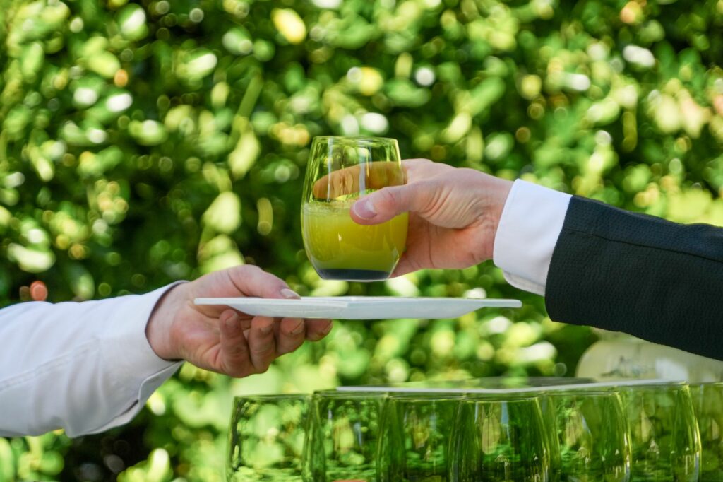 Verre de boisson verte servi sur un plateau lors du cocktail