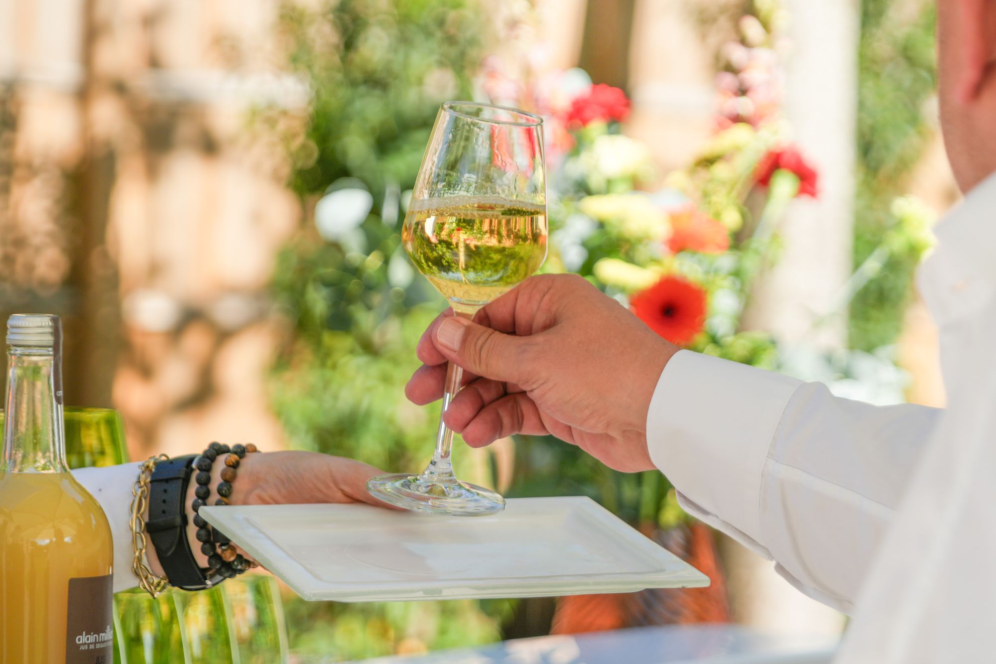Verre de vin blanc servi à un invité dans le jardin