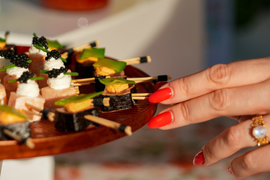 Invitée saisissant une brochette sur un plateau de bouchées