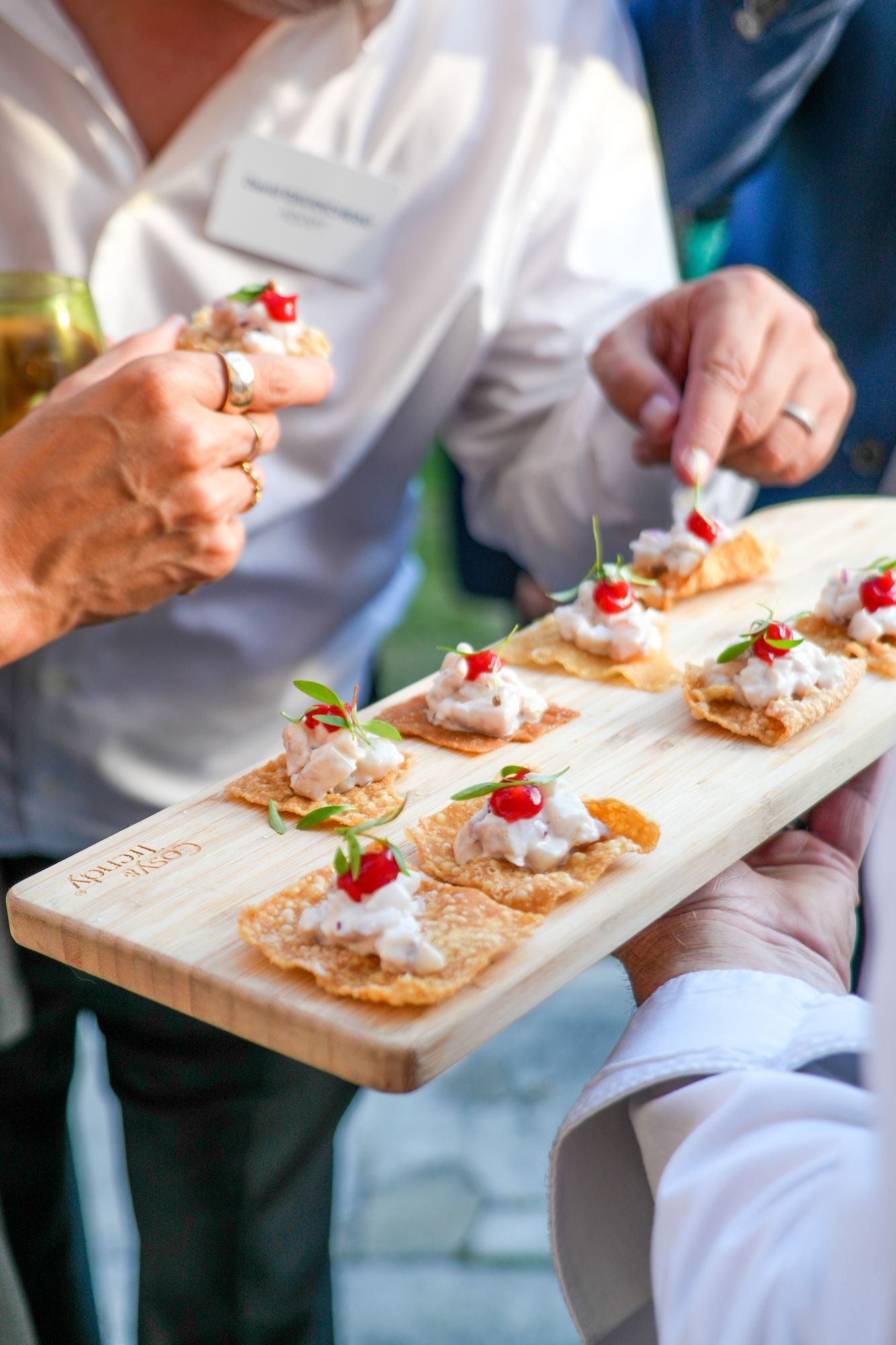 Invités se servant des toasts présentés sur une planche 4810 Traiteur