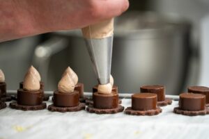 Pochage de crème sur des petits gâteaux au chocolat