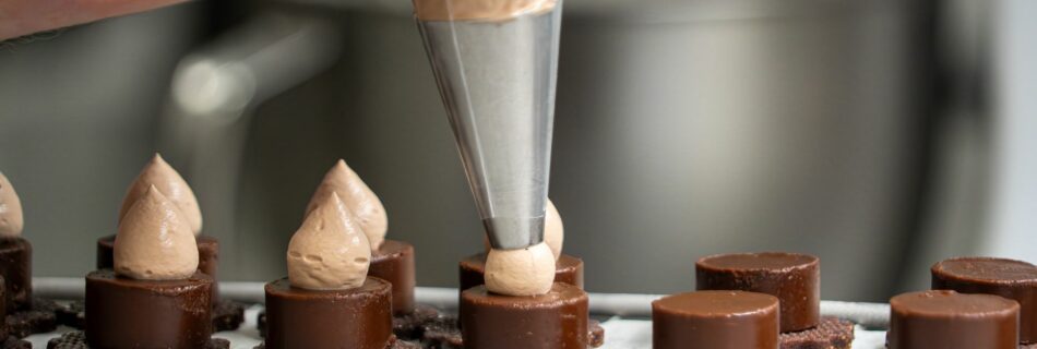 Pochage de crème sur des petits gâteaux au chocolat