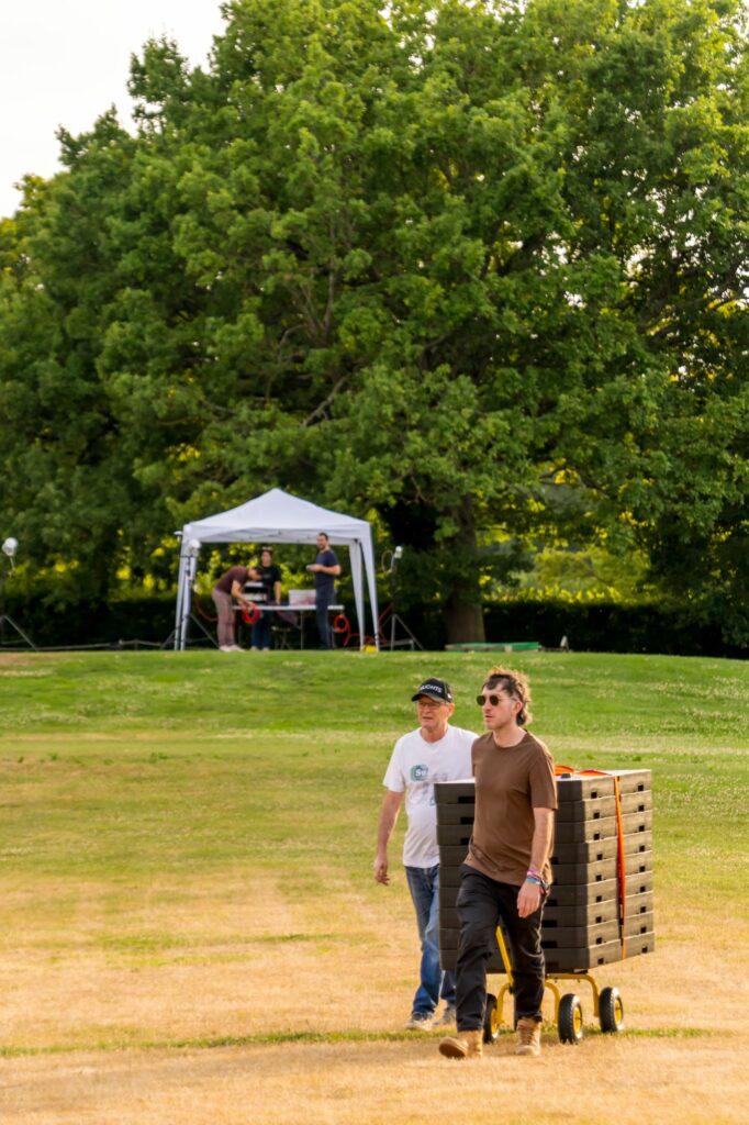Équipe Hilights tirant un chariot de mallettes de drones sur le parcours de golf