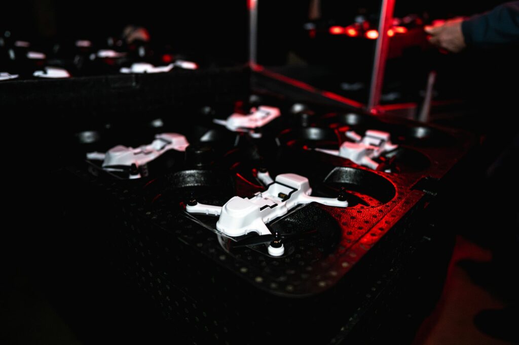 Drones blancs dans leurs mallettes sous une lumière rouge