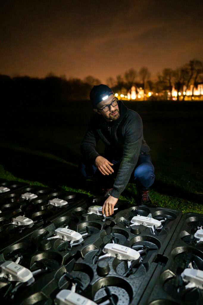 Technicien à la lampe frontale vérifiant les drones au sol
