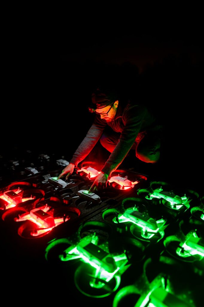 Technicien contrôlant des drones allumés en rouge et vert