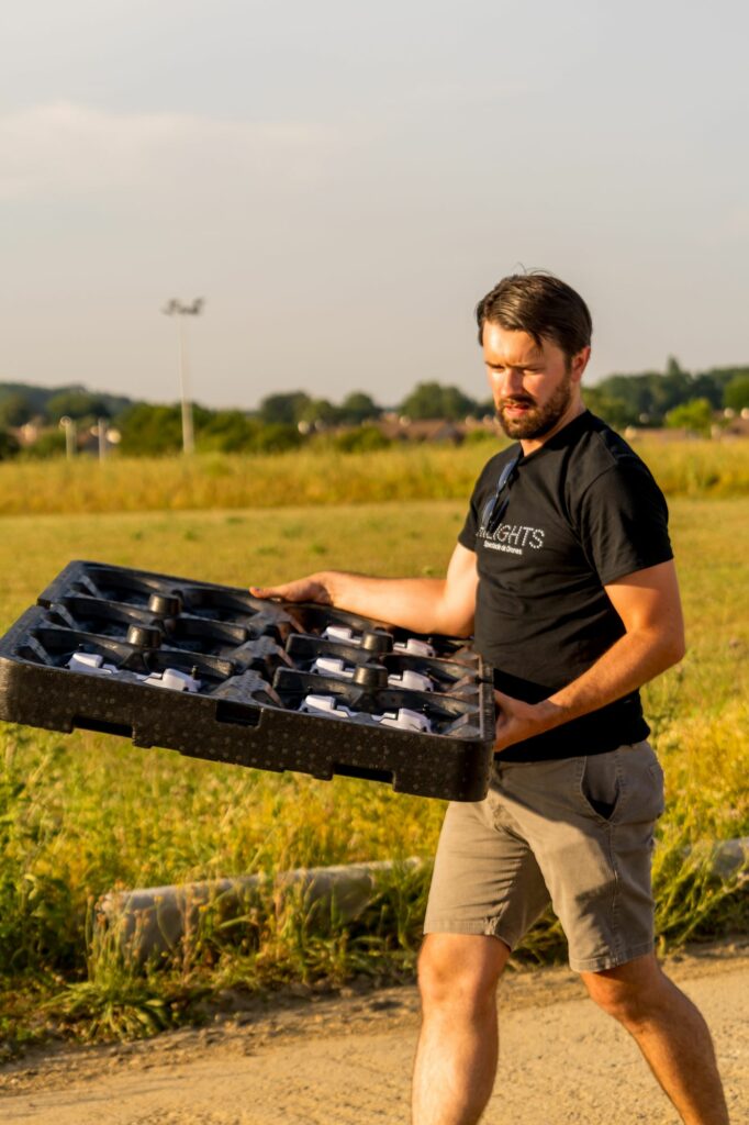 Membre de l'équipe Hilights transportant une mallette de drones sur le terrain
