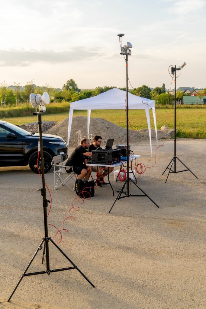 Station de pilotage du spectacle de drones installée sous une tonnelle, entourée d'antennes