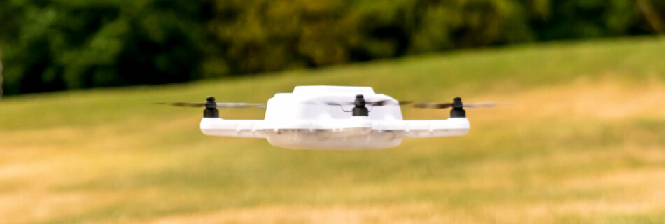 Drone blanc en vol stationnaire au-dessus du green du golf