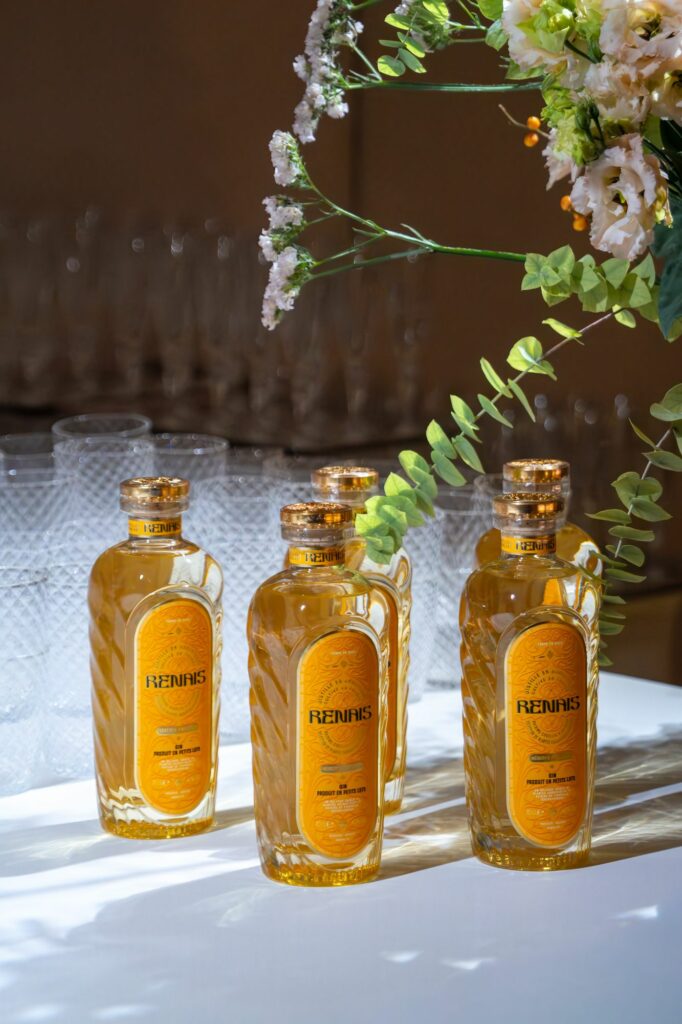 Bouteilles de boisson ambrée et bouquet de fleurs blanches sur le buffet