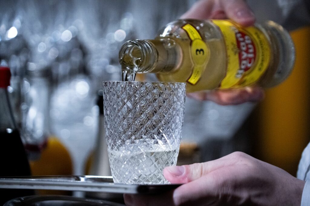 Serveur versant une boisson dans un verre en cristal ciselé