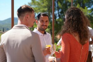 Invités discutant verre à la main au soleil