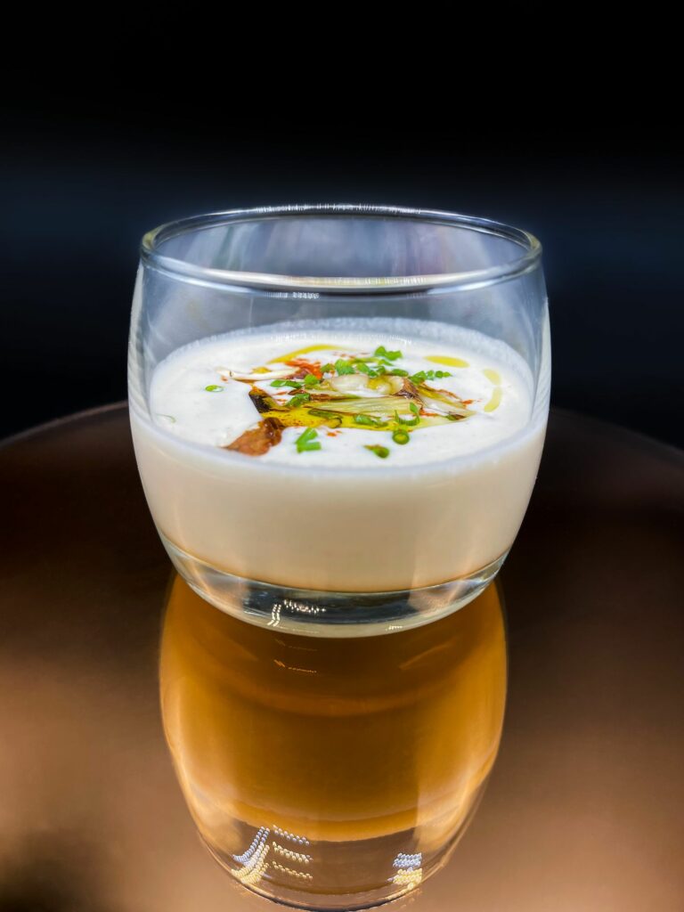 Verrine de velouté crémeux et herbes fraîches sur fond noir