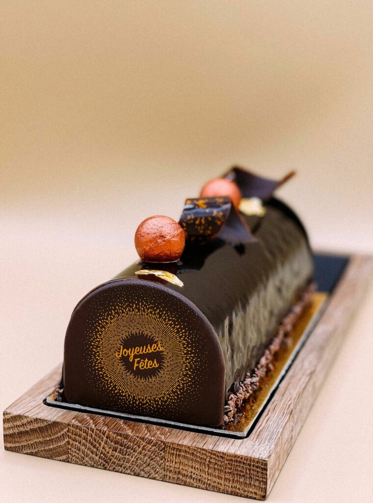 Bûche de Noël au chocolat « Joyeuses Fêtes » sur planche en bois
