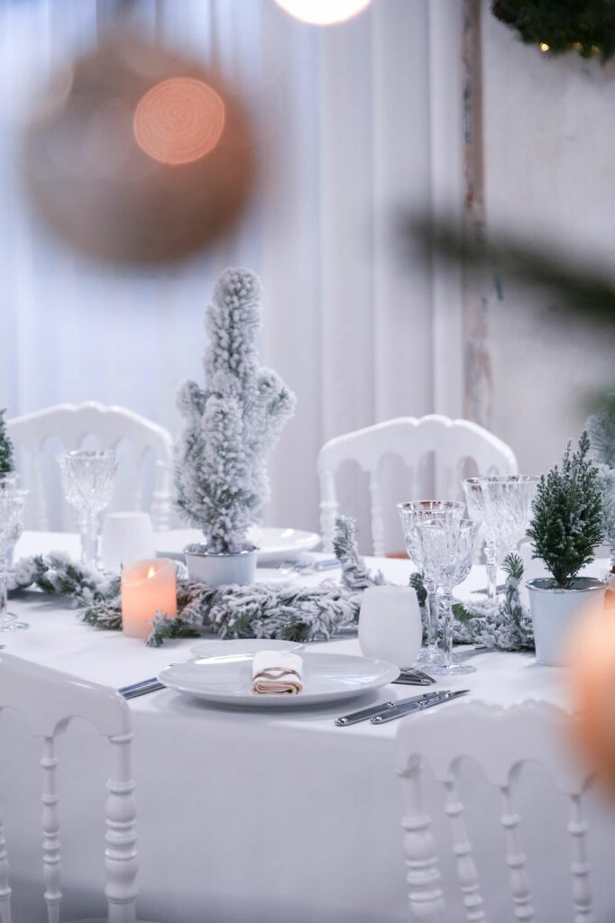 Mini sapin floqué et chaises blanches sur la table de Noël