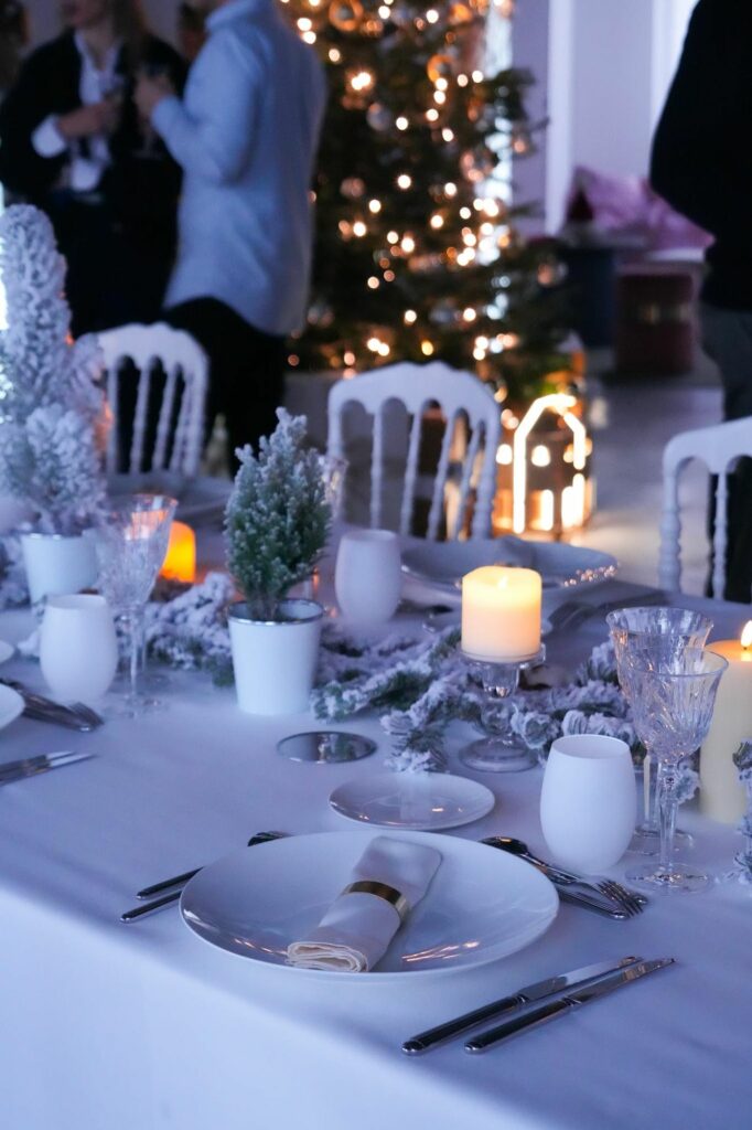 Table de Noël dressée devant un grand sapin illuminé